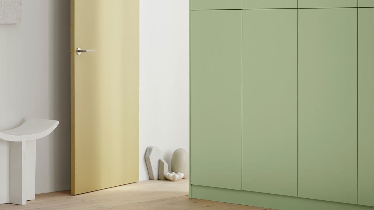 Rom som er malt i trendfarger fra Jotun: skap 7386 Pistachio, dør i gule 1775 Fresh Pasta og vegg i nøytralen 1622 Refleksjon.