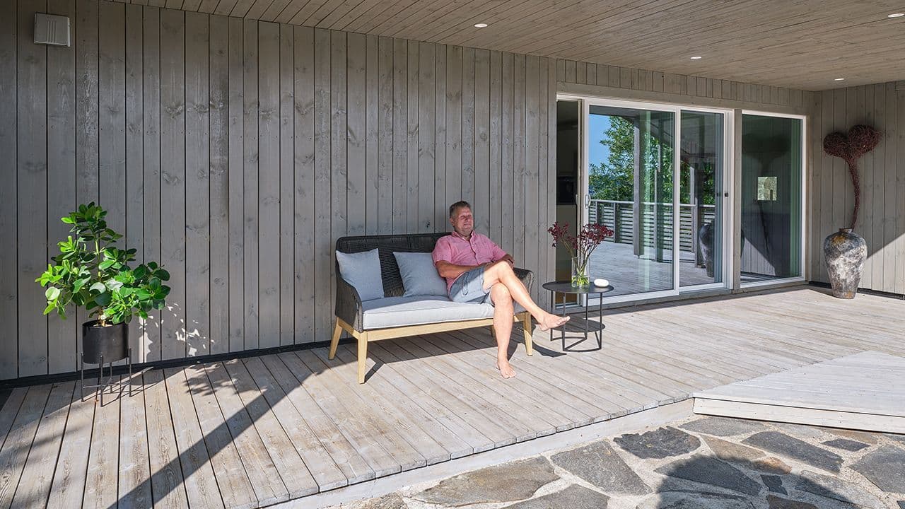 En mann som sitter i en sofa ute