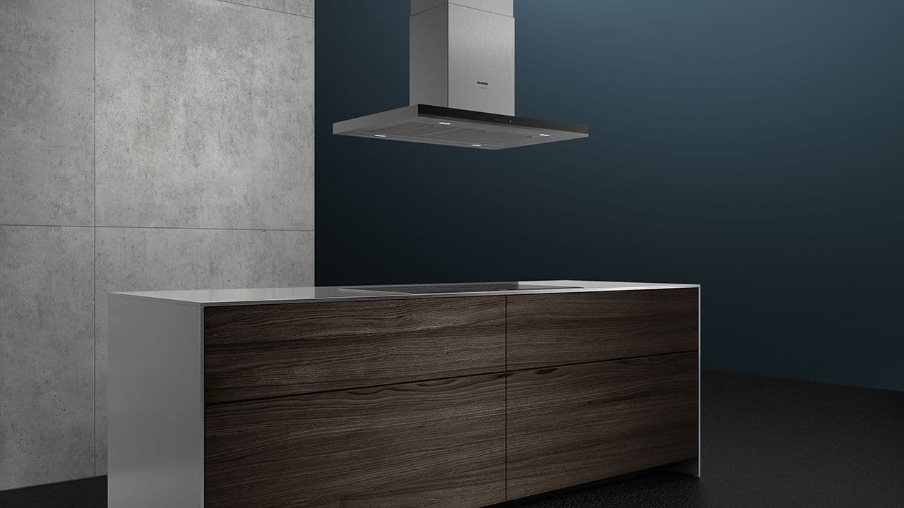 Fritthengende ventilator i krom over kjøkkenøy.