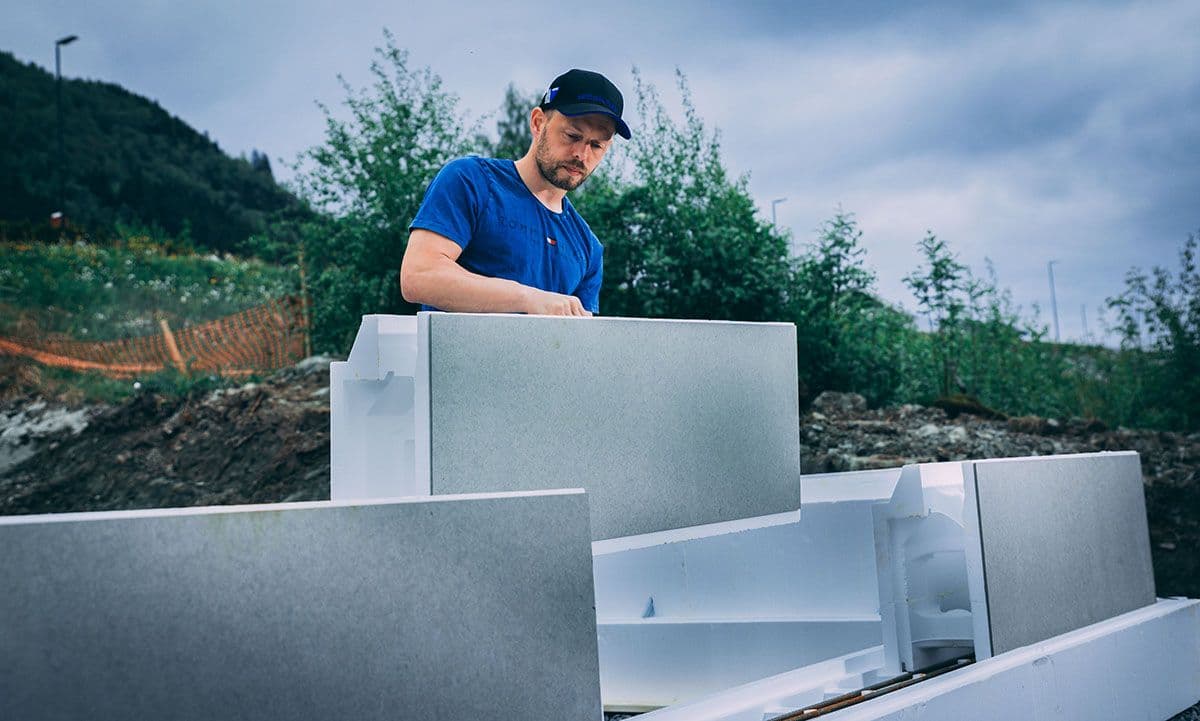 Håndverker som bygger mur med ringmur.