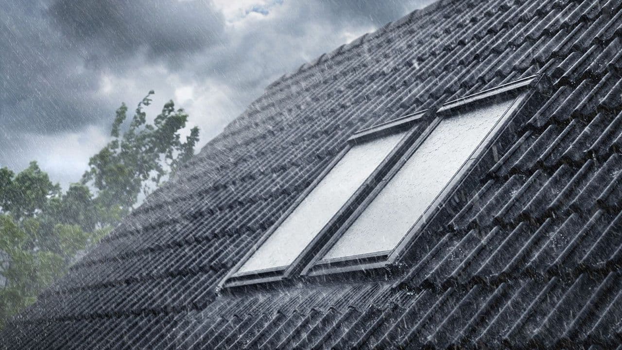 Nærbilde av tak og takvindu mens det regner.