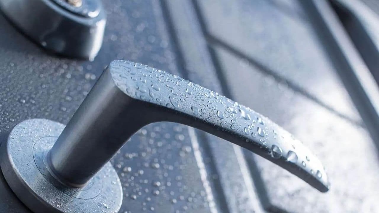 Ytterdør og dørhåndtak med regndråper på.