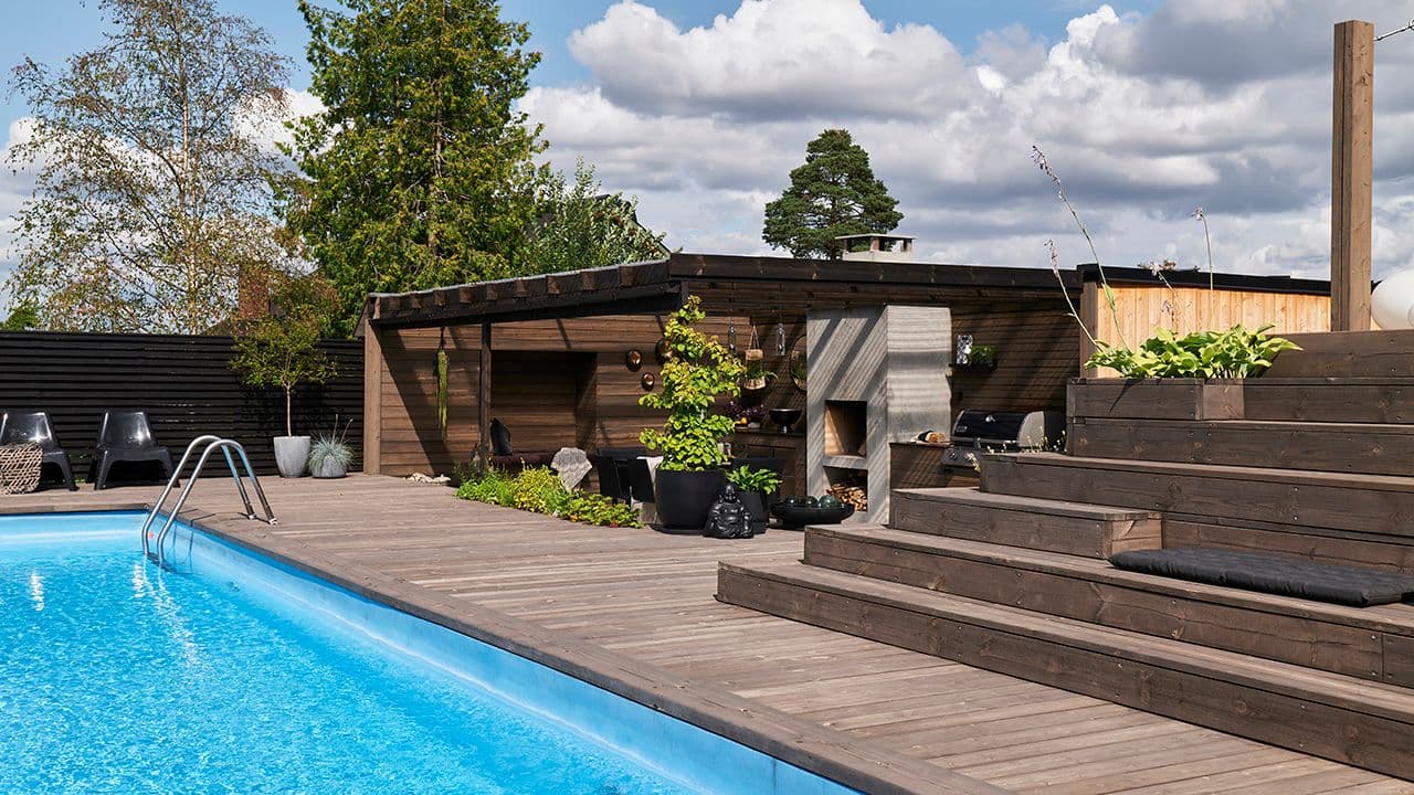 Inspirerende platting ved basseng med pergola og trapp.