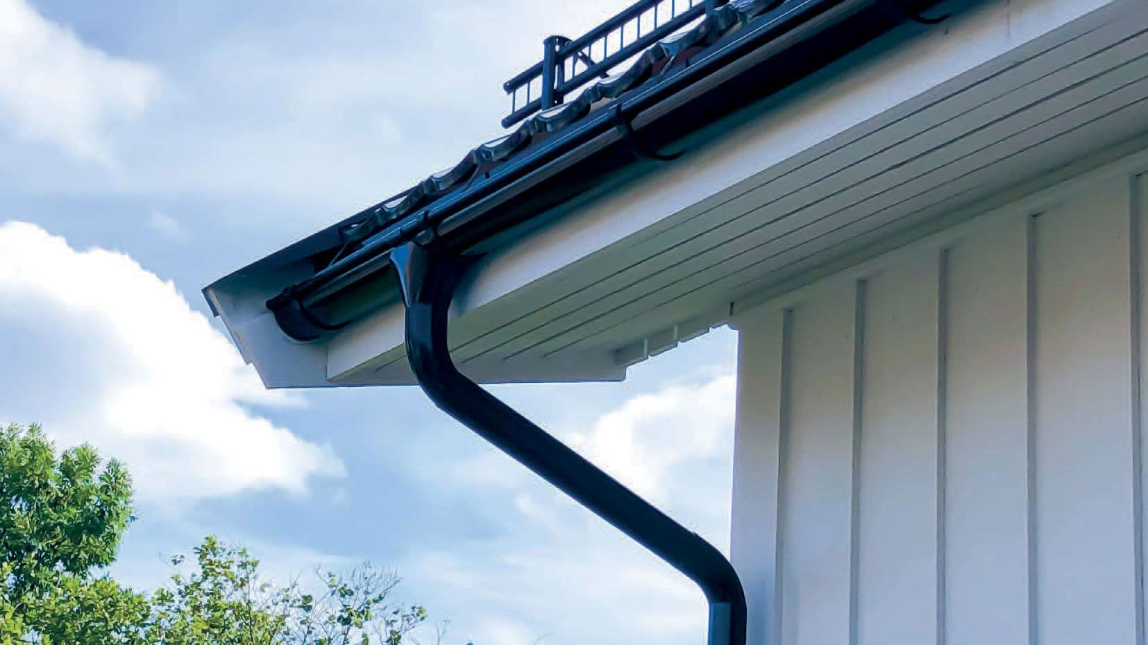 Svart Isola takrennesystem på hvitt hus.