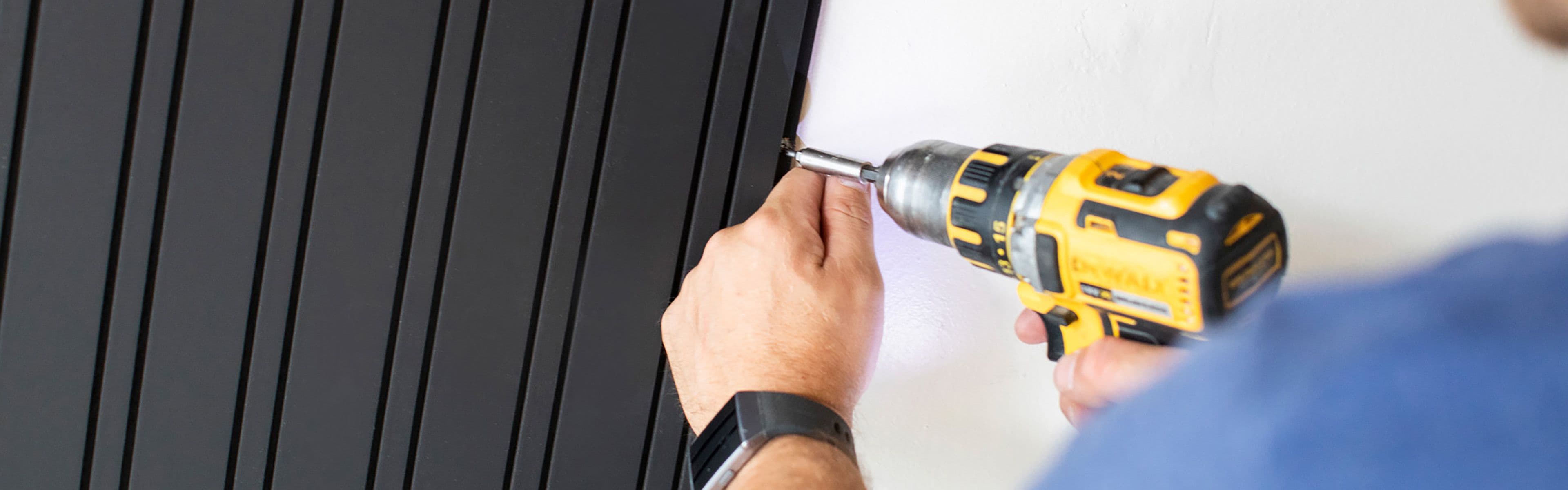 Mann monterer spilepanel på vegg