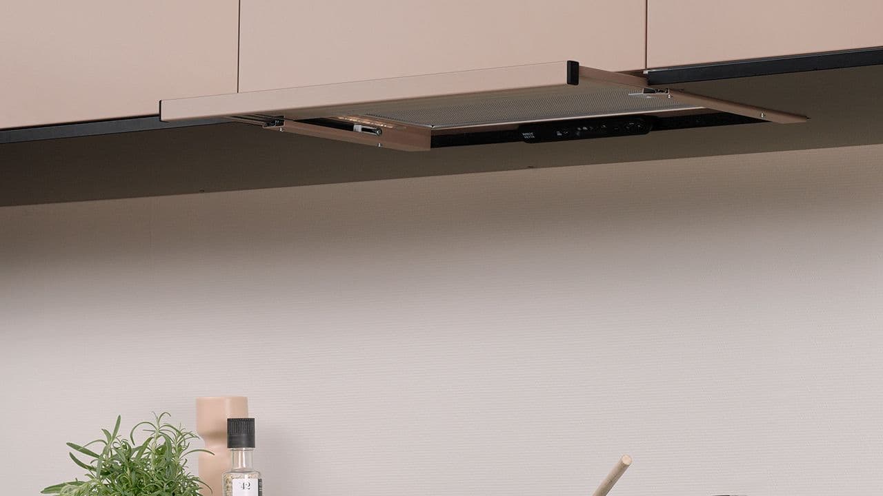 Kjøkkenvifte med uttrekk i ferskenfarget kjøkken.