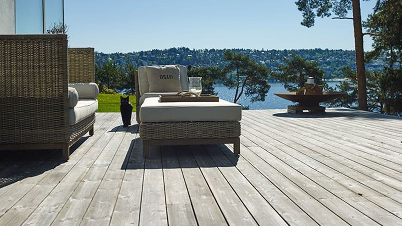 Platting med hagemøbler på hytta ved sjøen.