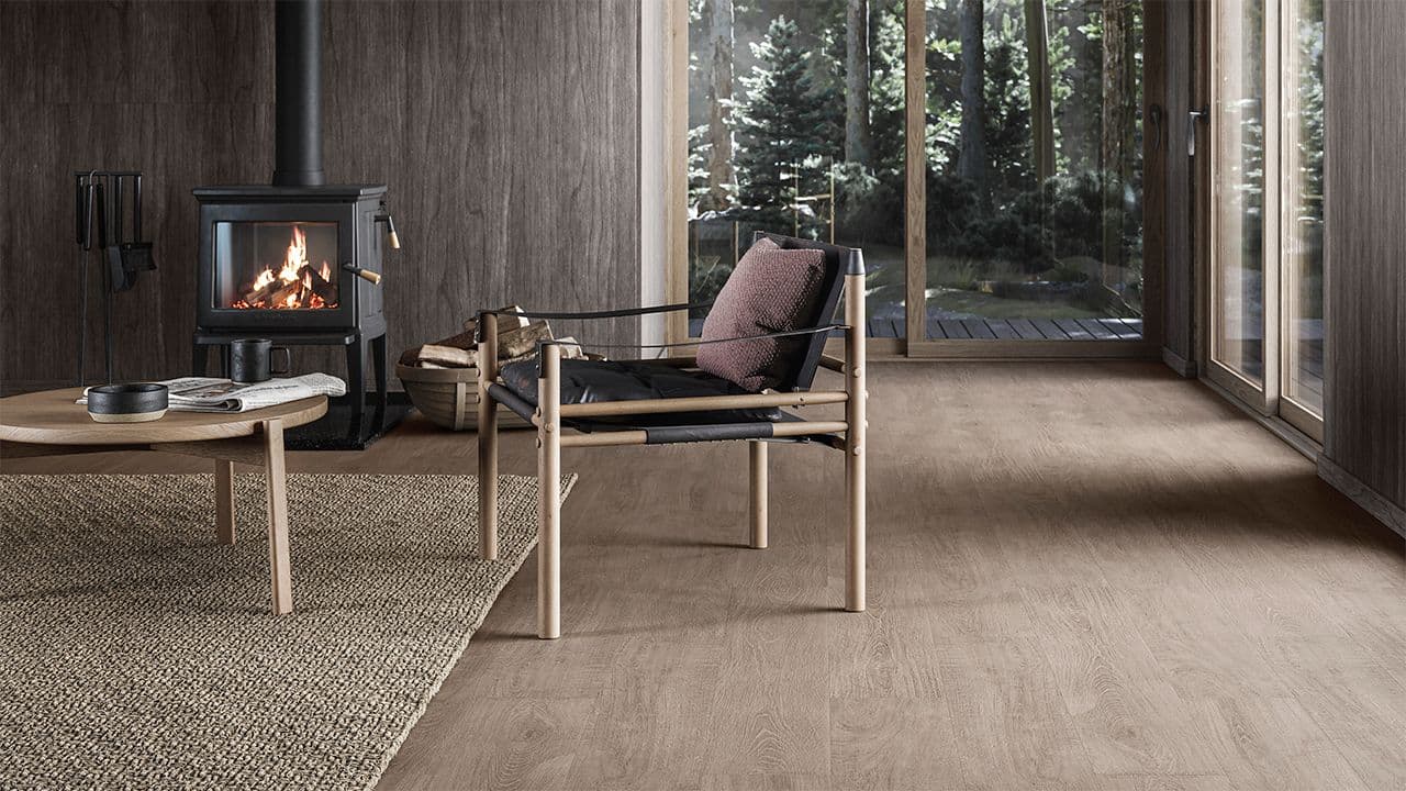 Moderne hytte med mørkt gulv og møbler i skandinavisk design.