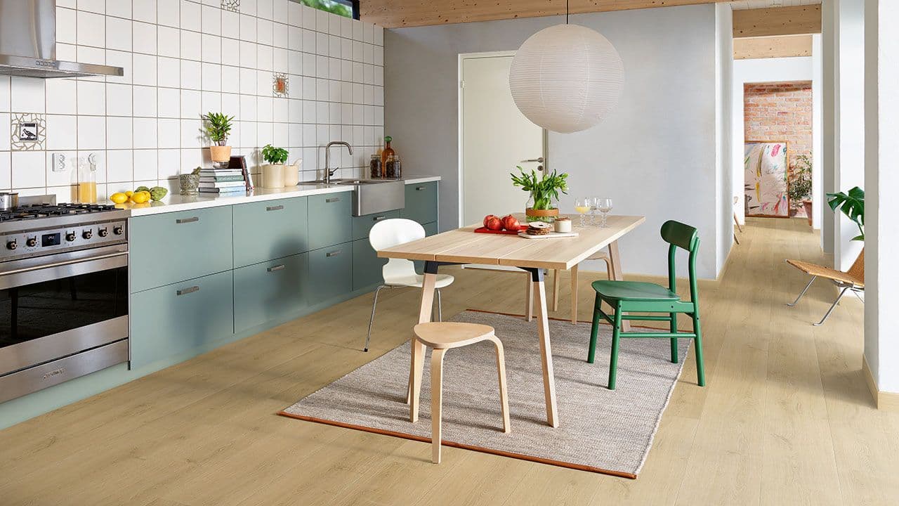 Lyst Pergo laminatgulv i hvitt og blått kjøkken.