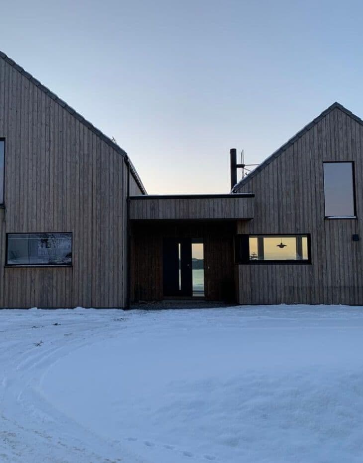 Svart ytterdør med glass på moderne hus.