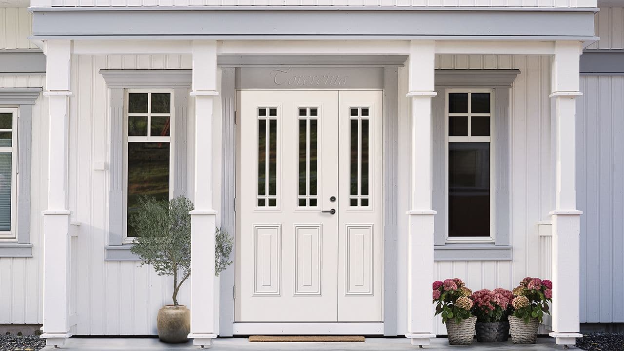 Herskapelig hus med hvit ytterdør med sidelt.