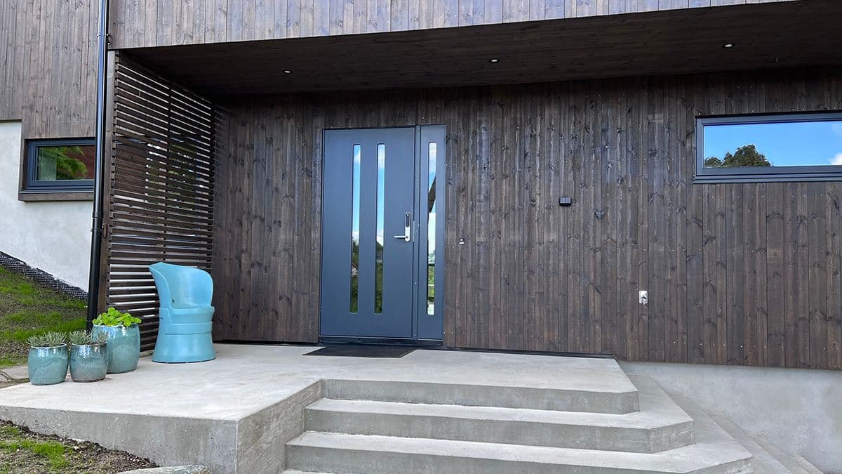 Svart ytterdør på trehus.